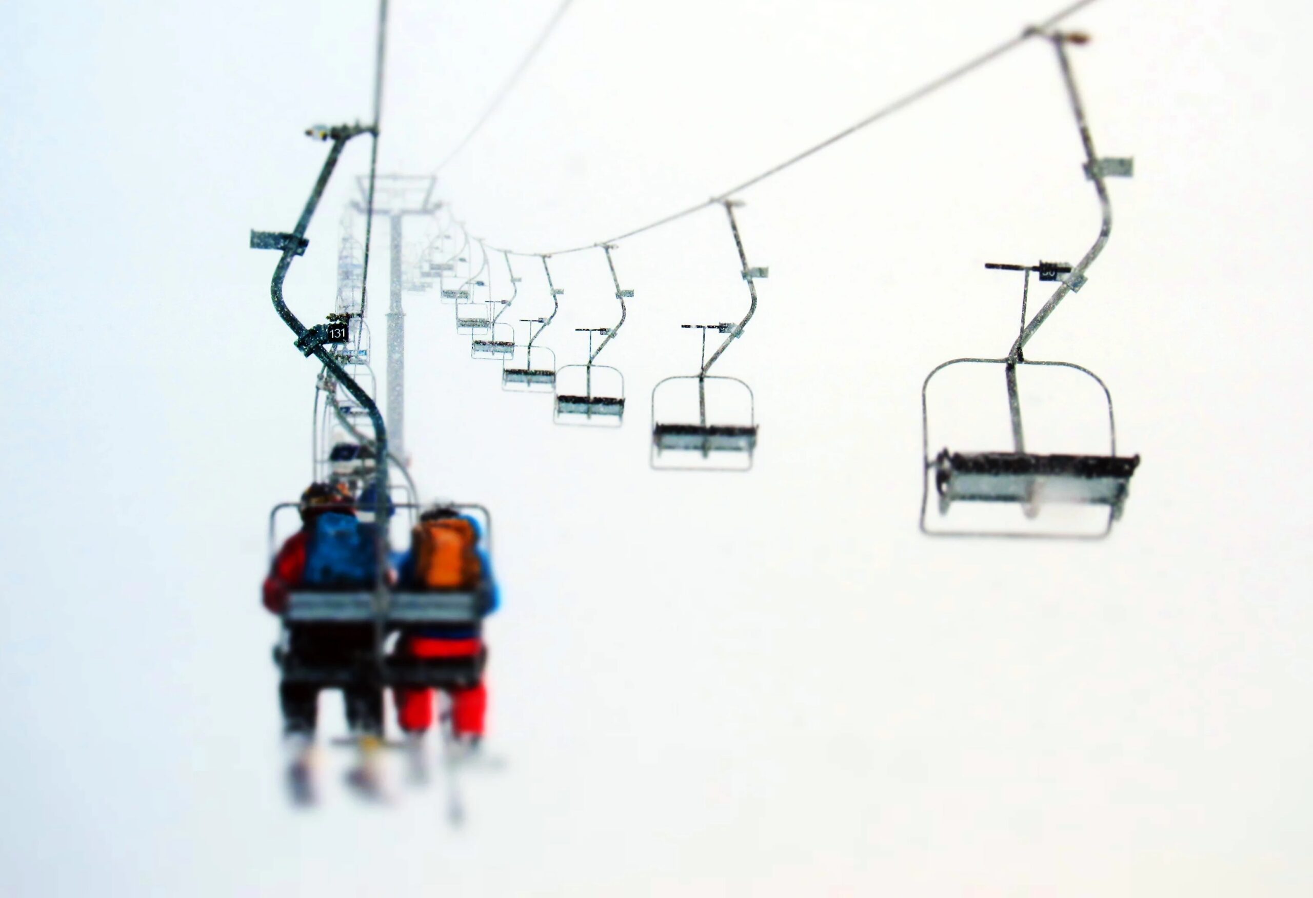 Skiers ride chairlift into the mist