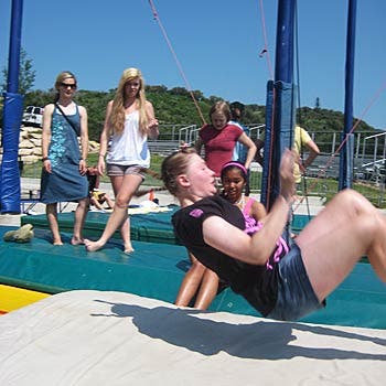    Campers practice on mats before heading over to the trampolines and finishing at the water ramps. Here, a camper demonstrates the right way to do…