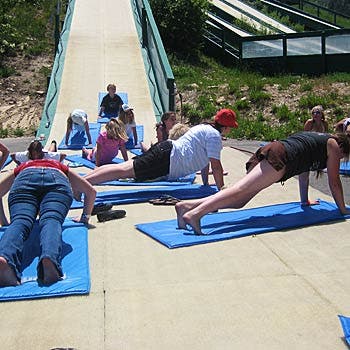 Stretch it Out Coaches Caroline Gleich (22) Olivia Akerley (18) and Elise Borelli (16) led the camp in some standard stretches before a big day of jumping. To…