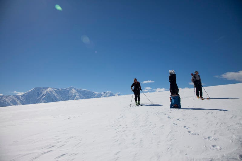 Kelly Okonek doing some yoga on Wiencke Island Kelly Okonek doing skier's yoga on Wiencke Island while guide Glen Poulsen (left) and skier Scott Fennell (right) stand by.