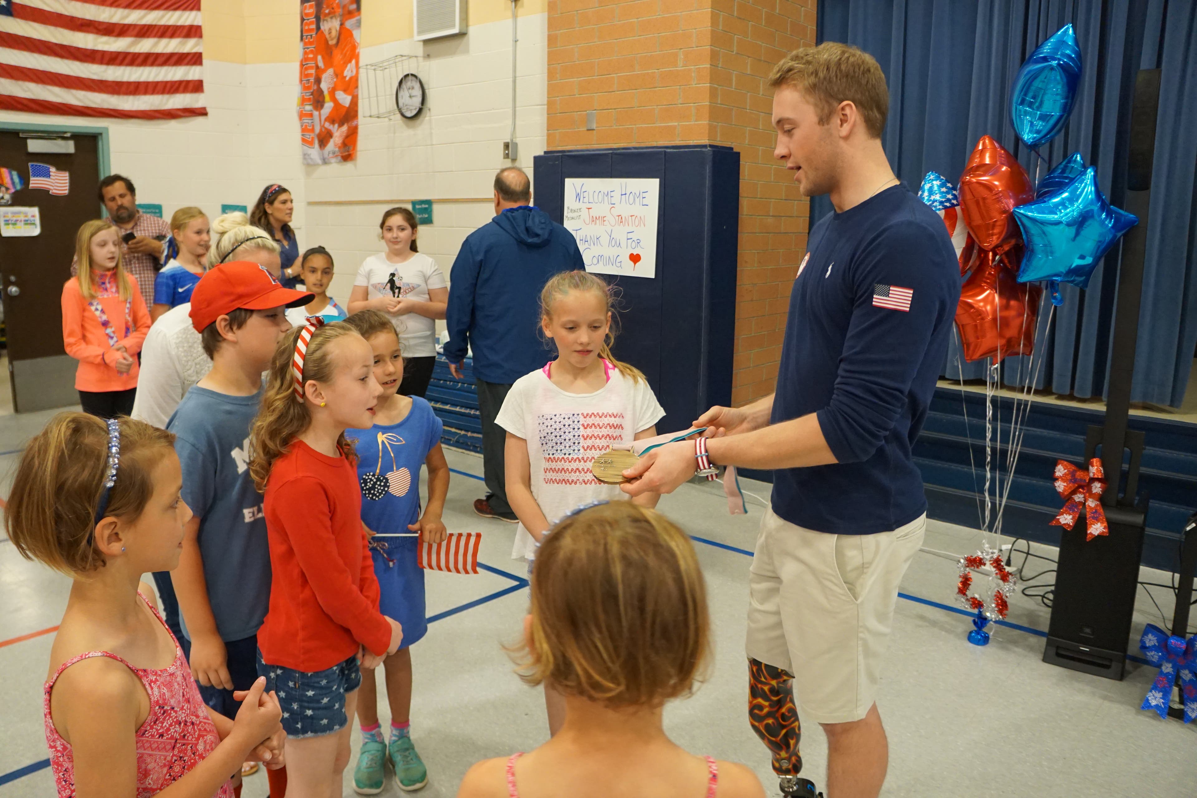 DSC08784 Jamie Stanton shows his Olympic bronze medal to a group of elementary school children.