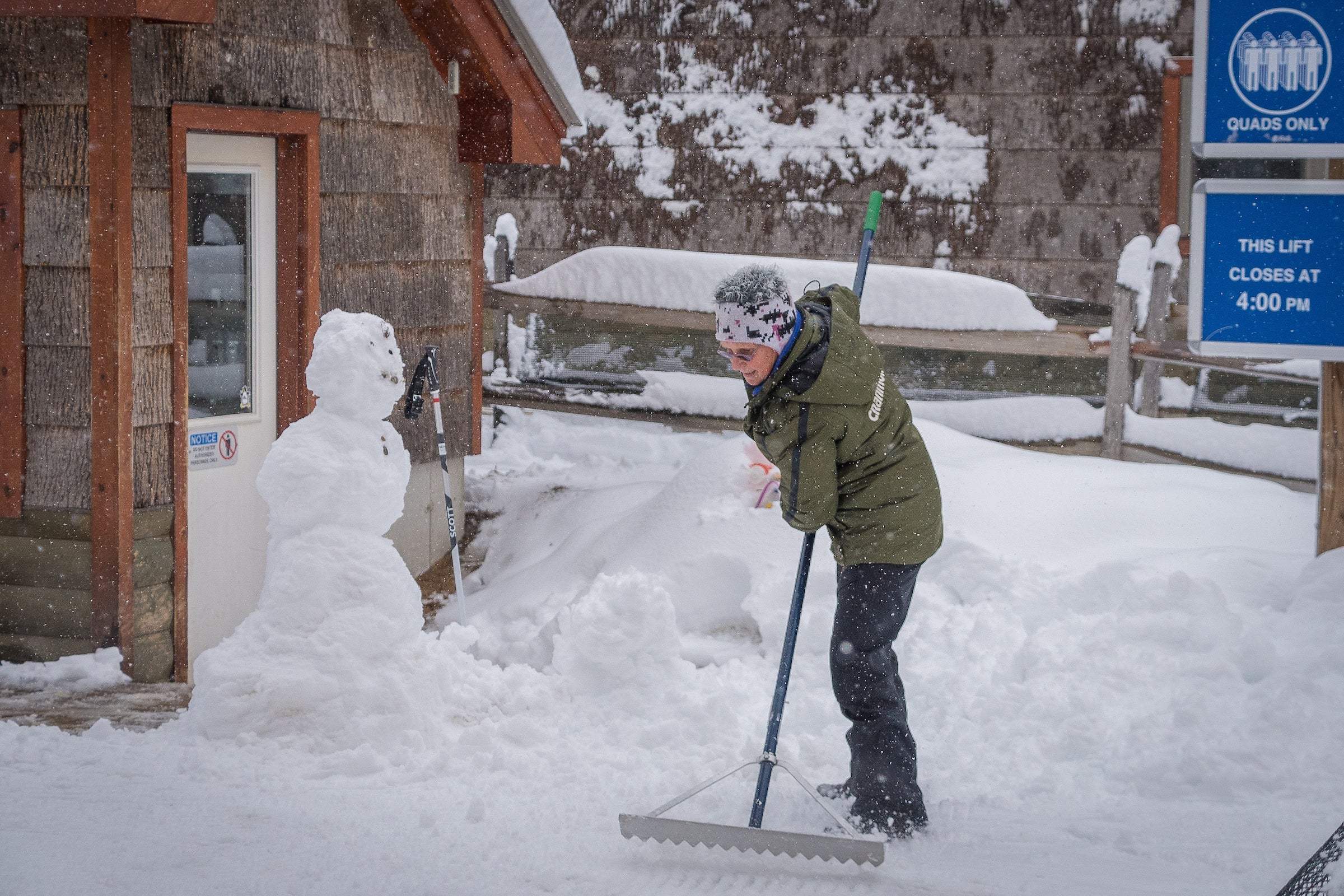 "Cindy rakes snow at the base of the lift."