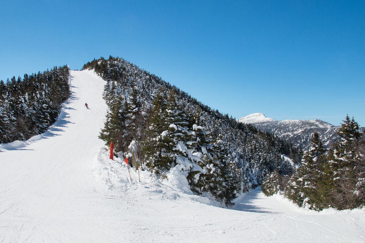 The top of Madonna Mountain is oh-so Vermont, especially with Mt. Mansfield poking up in the distance. This skier is cruising Upper Chilcoot from the…