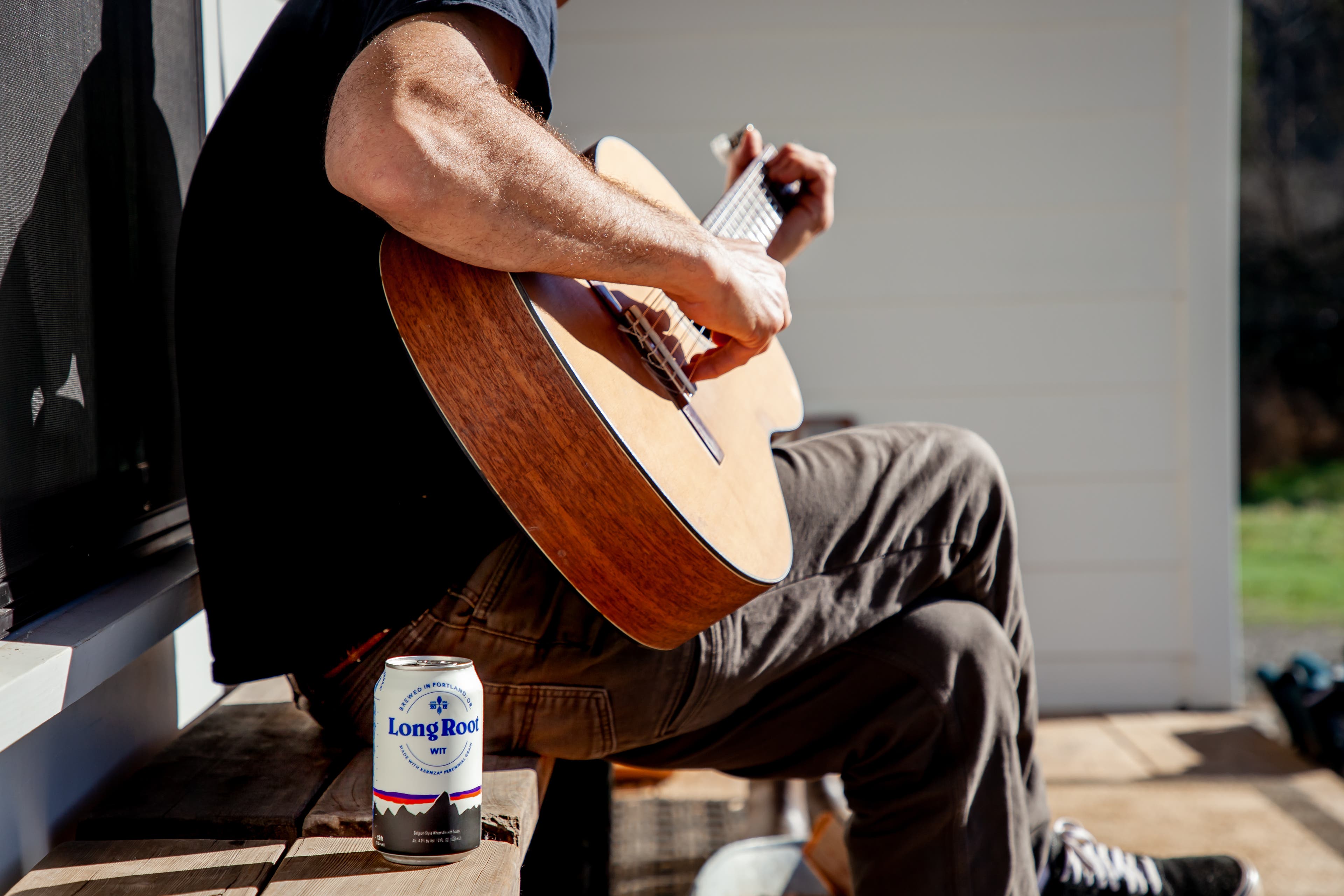 Strumming a guitar and drinking a beer