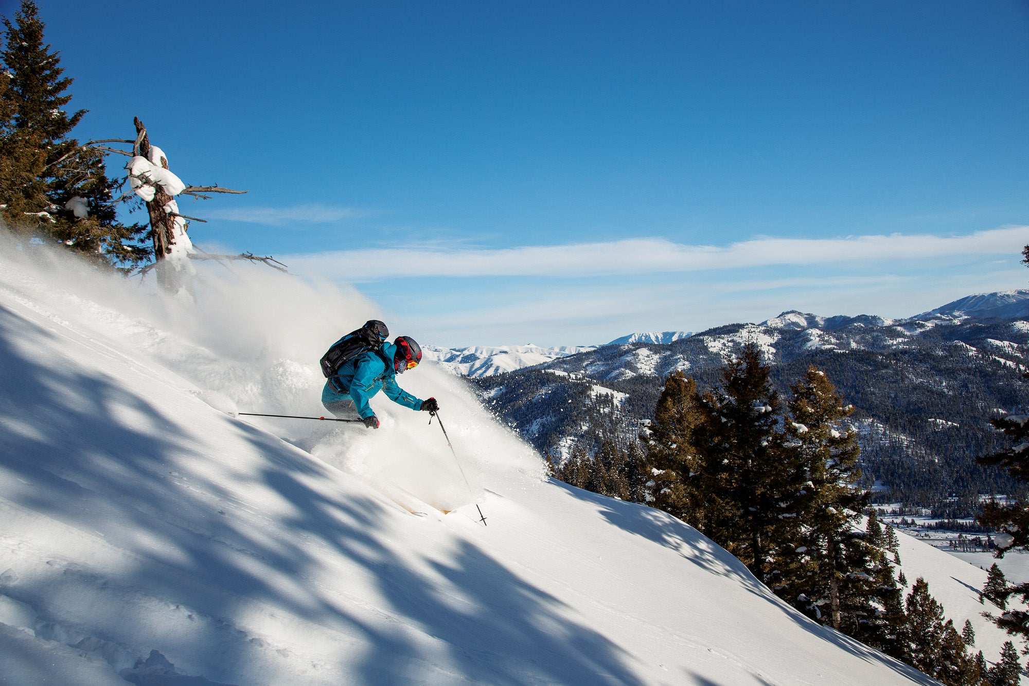 "Skier in blue jacket skiing down slope at Sun Valley Resort, Idaho"