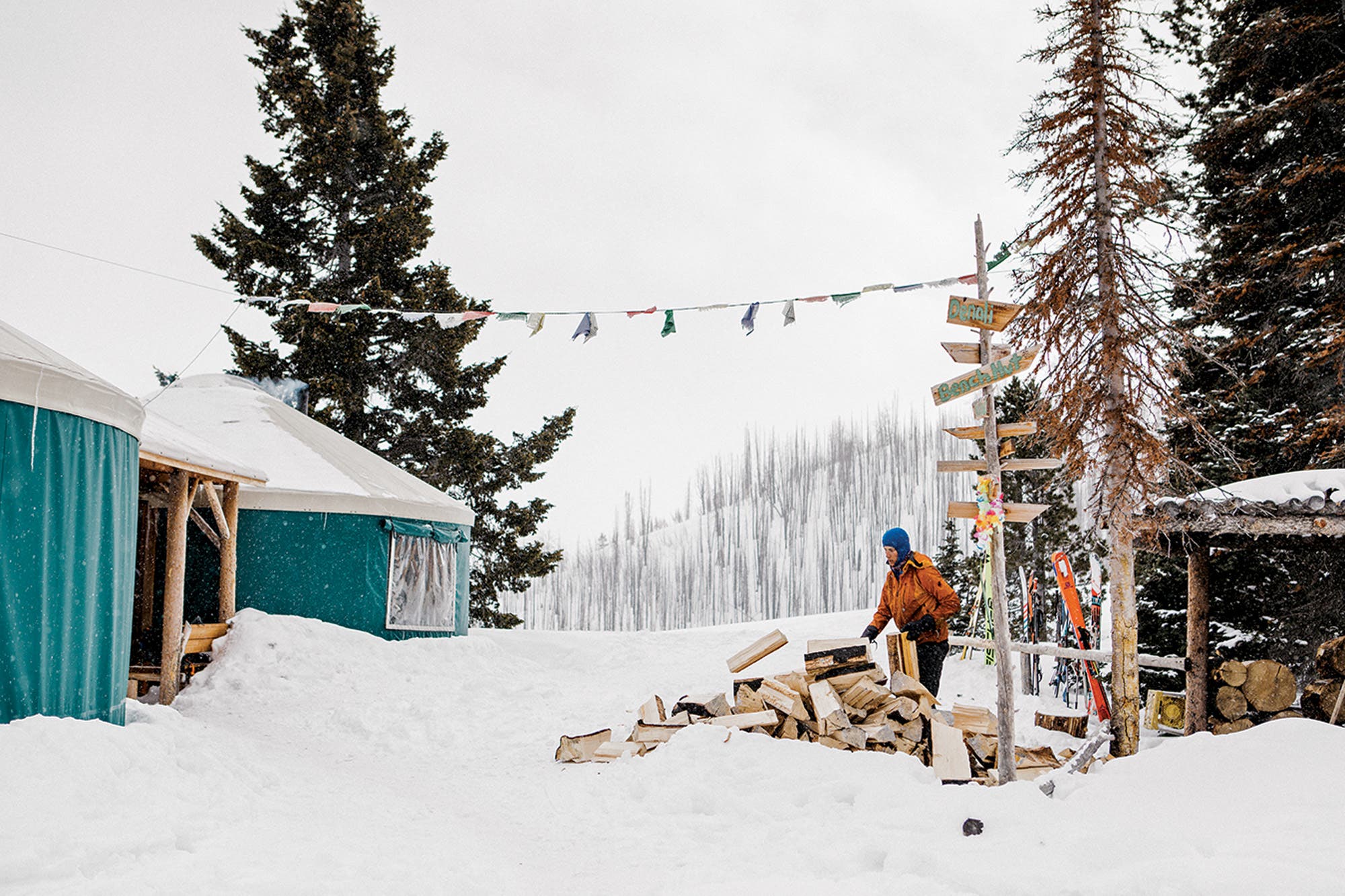Man gathering wood outside Coyote Yurt in Sun Valley, Idaho