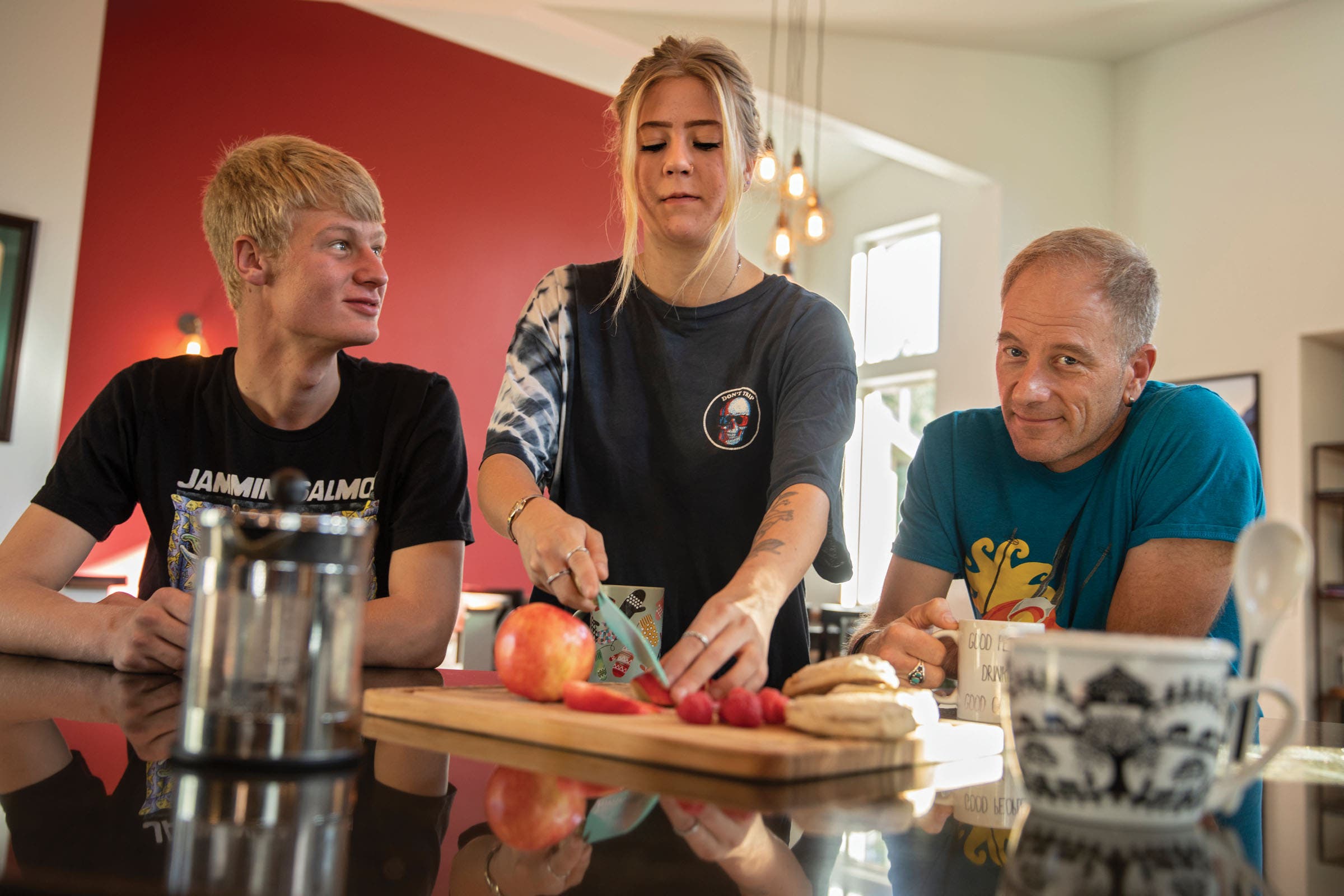 Sven Brunso with daughter Aspen and son Stowe cutting fruit