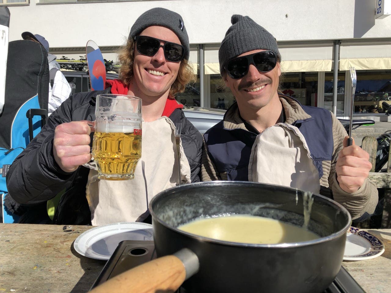 Connery Lundin and Marcus Caston drinking beer and eating fondue in Switzerland