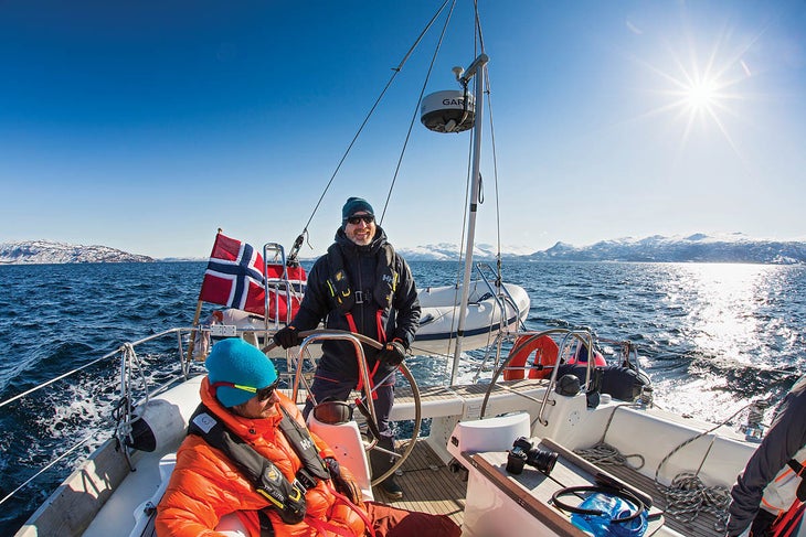 Cameron Martindell steers a sailboat through the Norwegian Fjords.