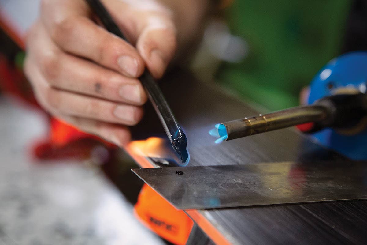SKI0120-Tuning2-BaseRepair How to repair damaged ski bases. Step 2: Heat P-Tex stick with butane torch.