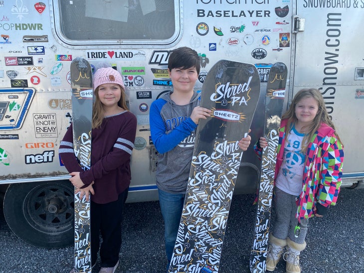 Shred PA Photo 3 Three participants in the SkiPA 4th and 5th Grade Snowpass Program hold up their free skis and snowboards from Gilson Snow