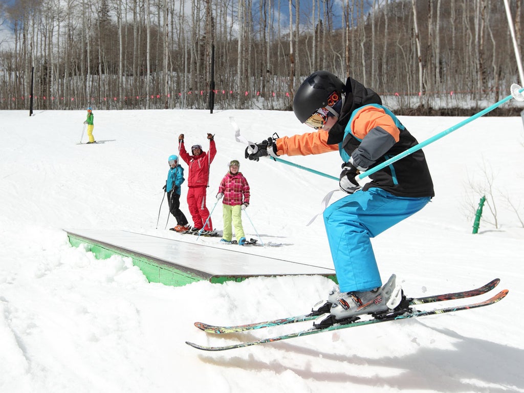 Kid practices tricks on skis
