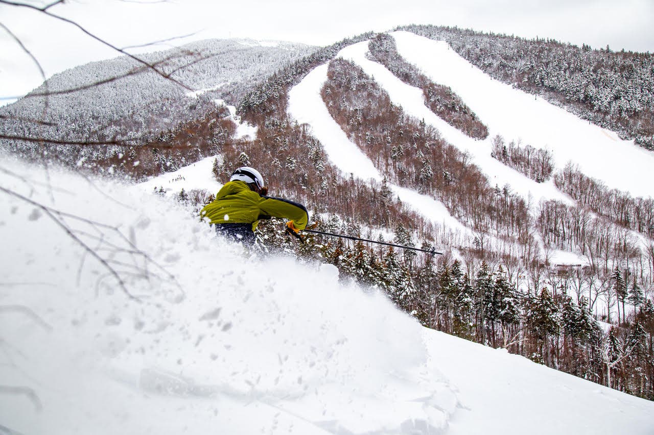 Skier skis powder at Waterville Valley Resort