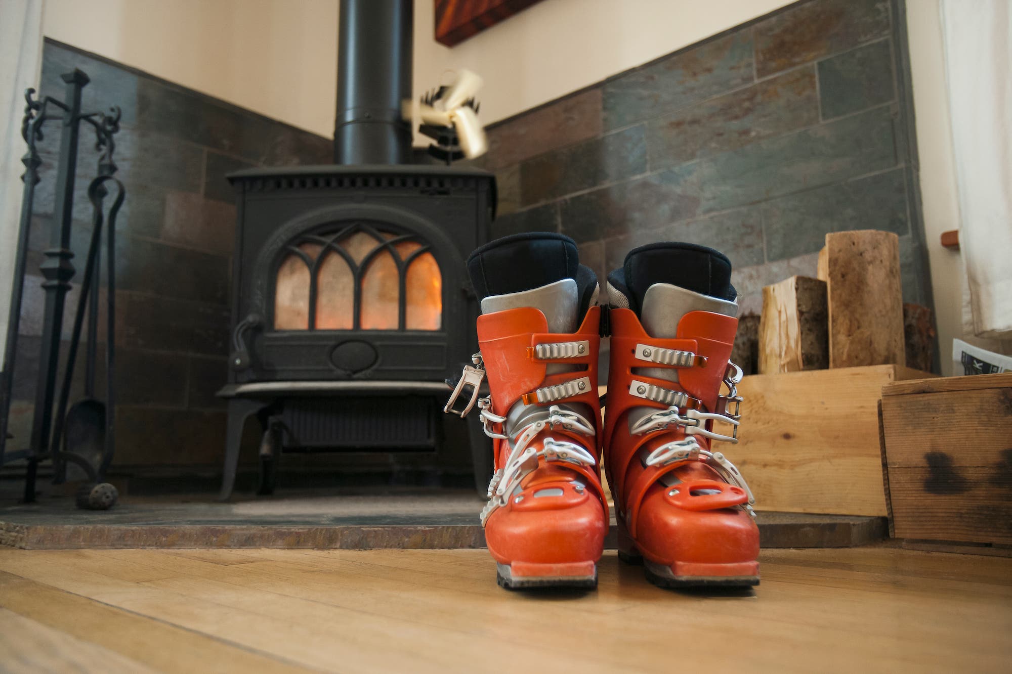 Old ski boots in front of wood burning stove