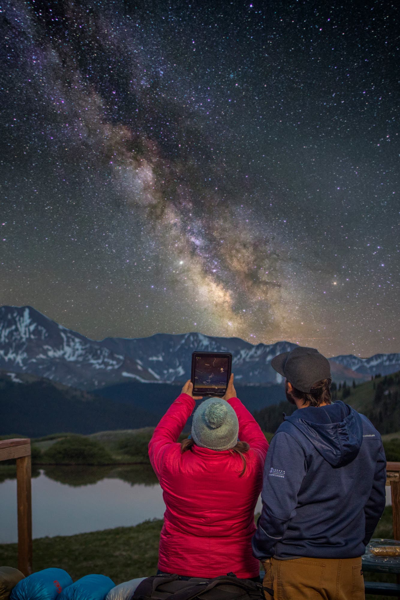two people look at stars in the mountains