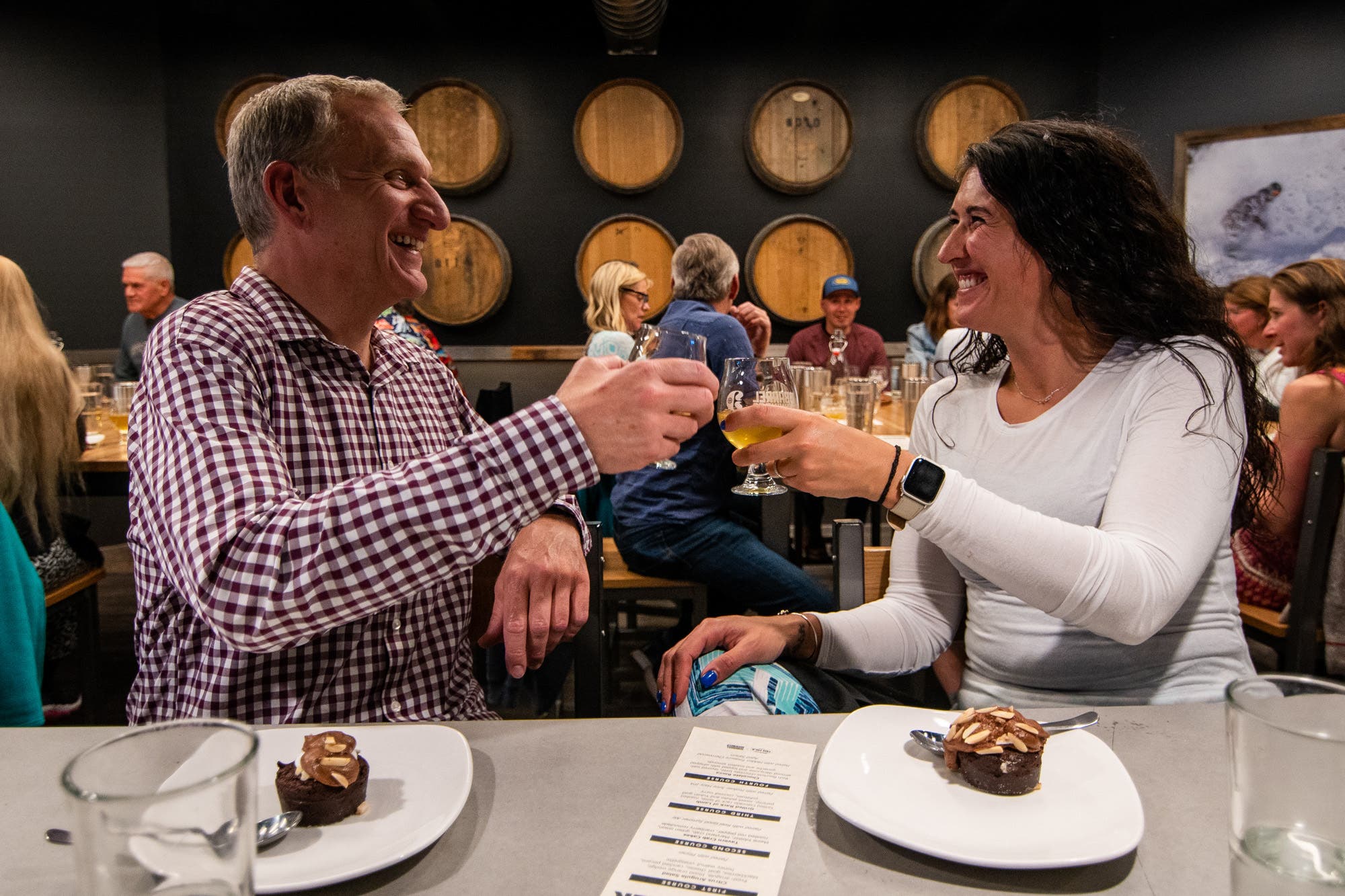 Two people clinking beer glasses