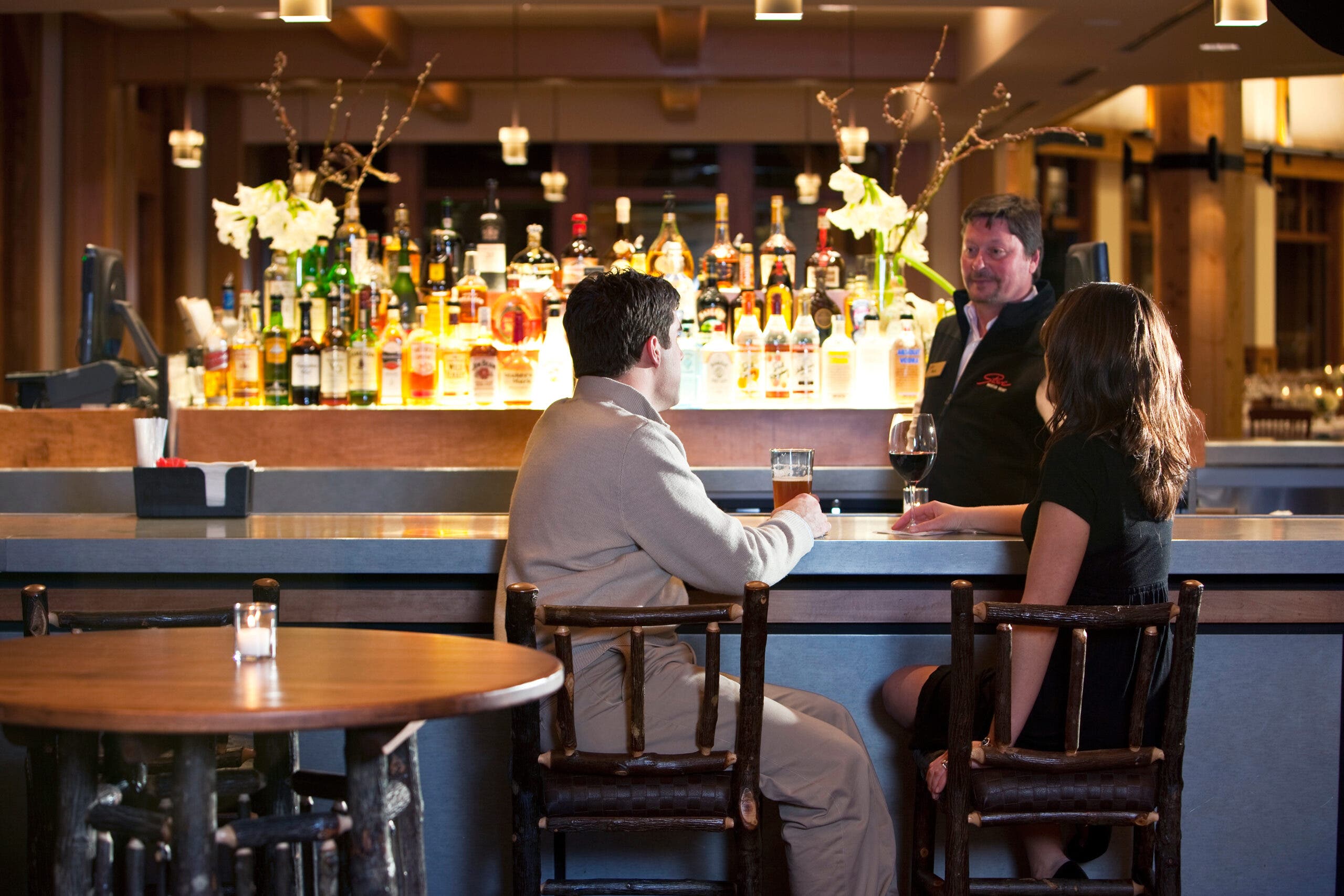 Two people enjoy a drink at the bar.