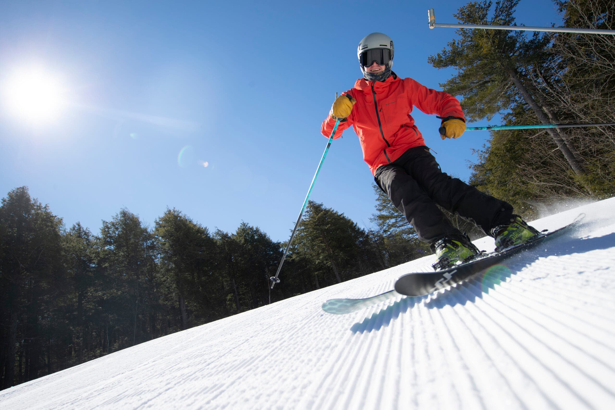 skier in red goes down groomer