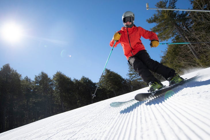 skier in red goes down groomer