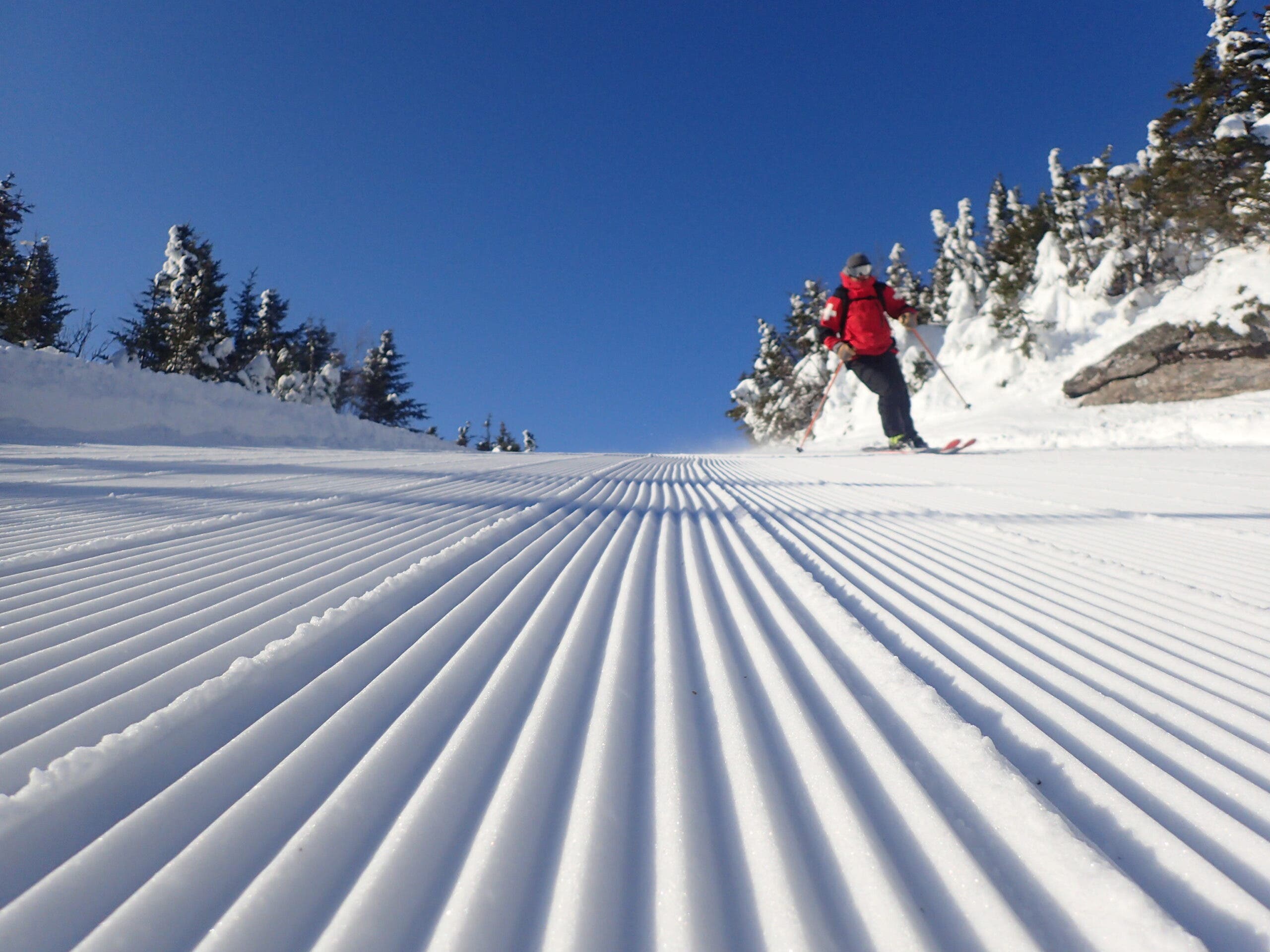 Skier in red on well groomed trail