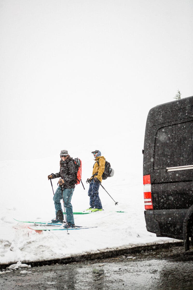 Skiers return to their van in parking lot