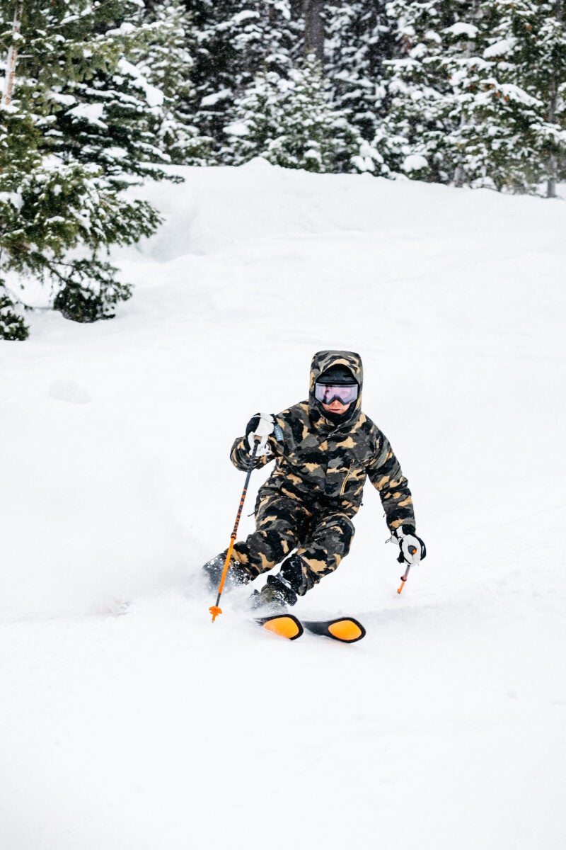 Skier in a camo suit plows down mountain