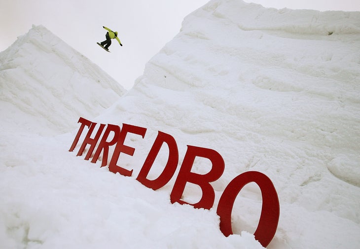 Snowboarder jumps between two large mounds