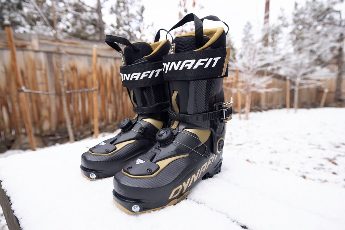 Black and gold Dynafit Ridge Pro backcountry ski boots on snowy picnic table