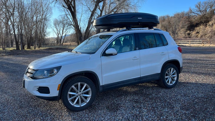 Closeup of white SUV with modern roof box carrier on top