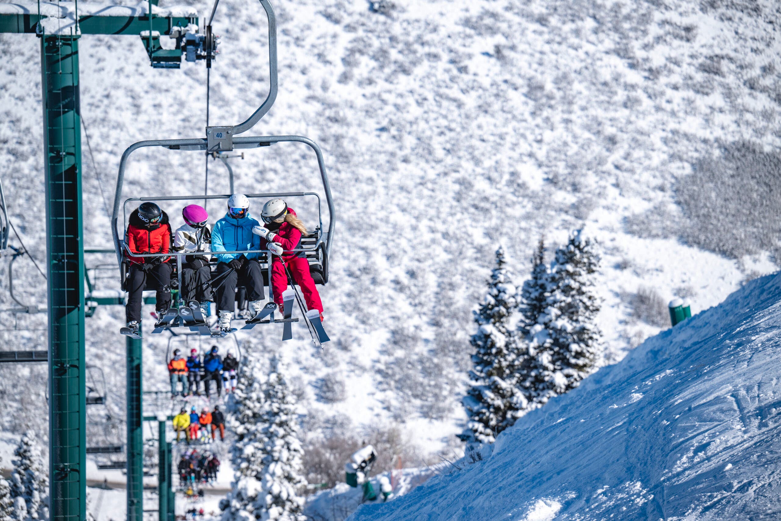 Shot of skiers on chairlift with one on focus of four skiers.