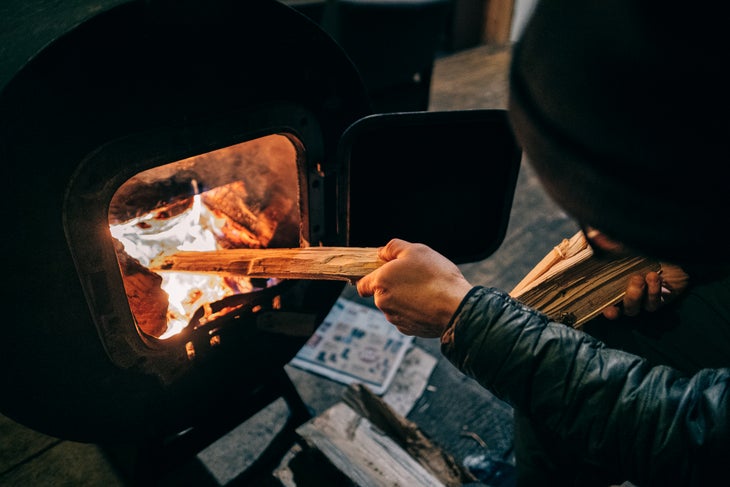 someone puts fire log into the fire