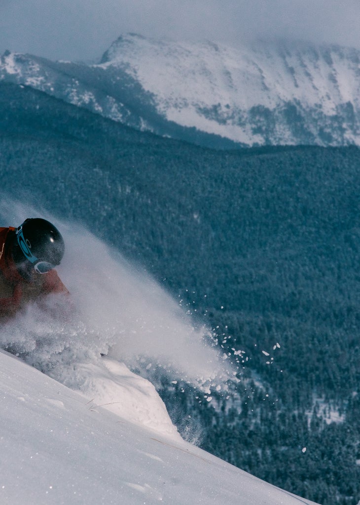 Skier in a red jacket goes down slope