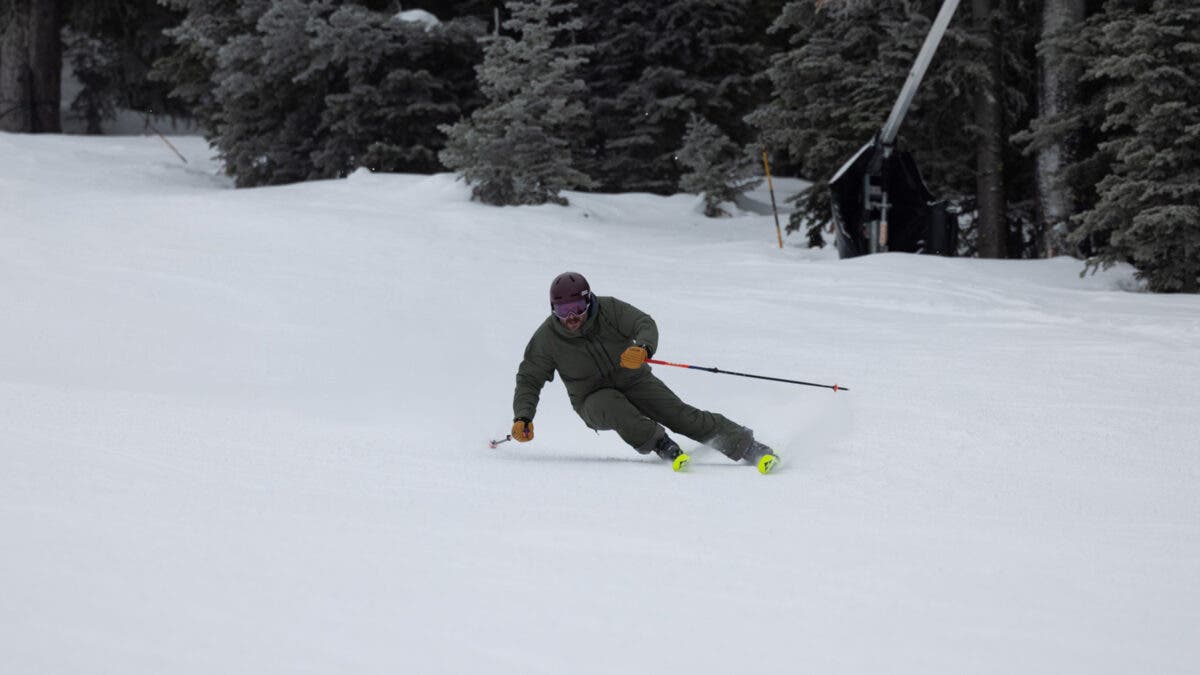 Man carving on Fischer RC4 Noize ski down groomed slope