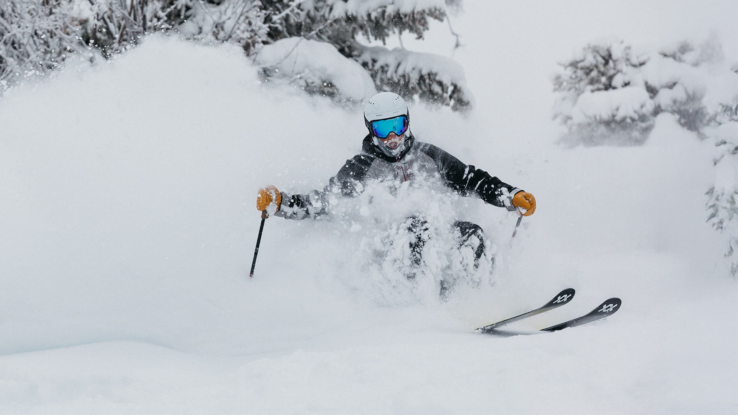 Skier turning in deep snow on powder skis during SKI's annual gear test