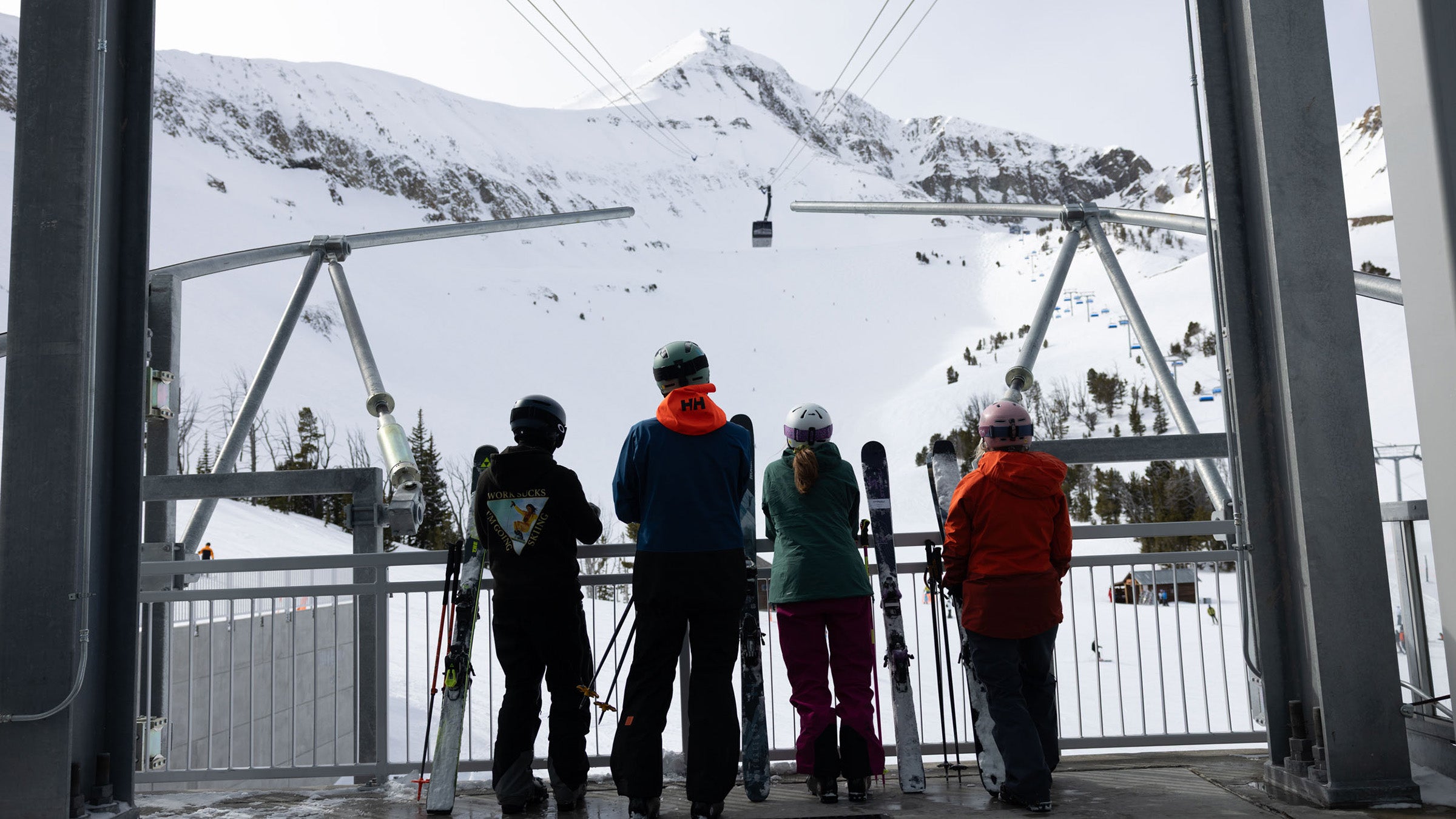 Skiers looking up at Big Sky tram from tram station.