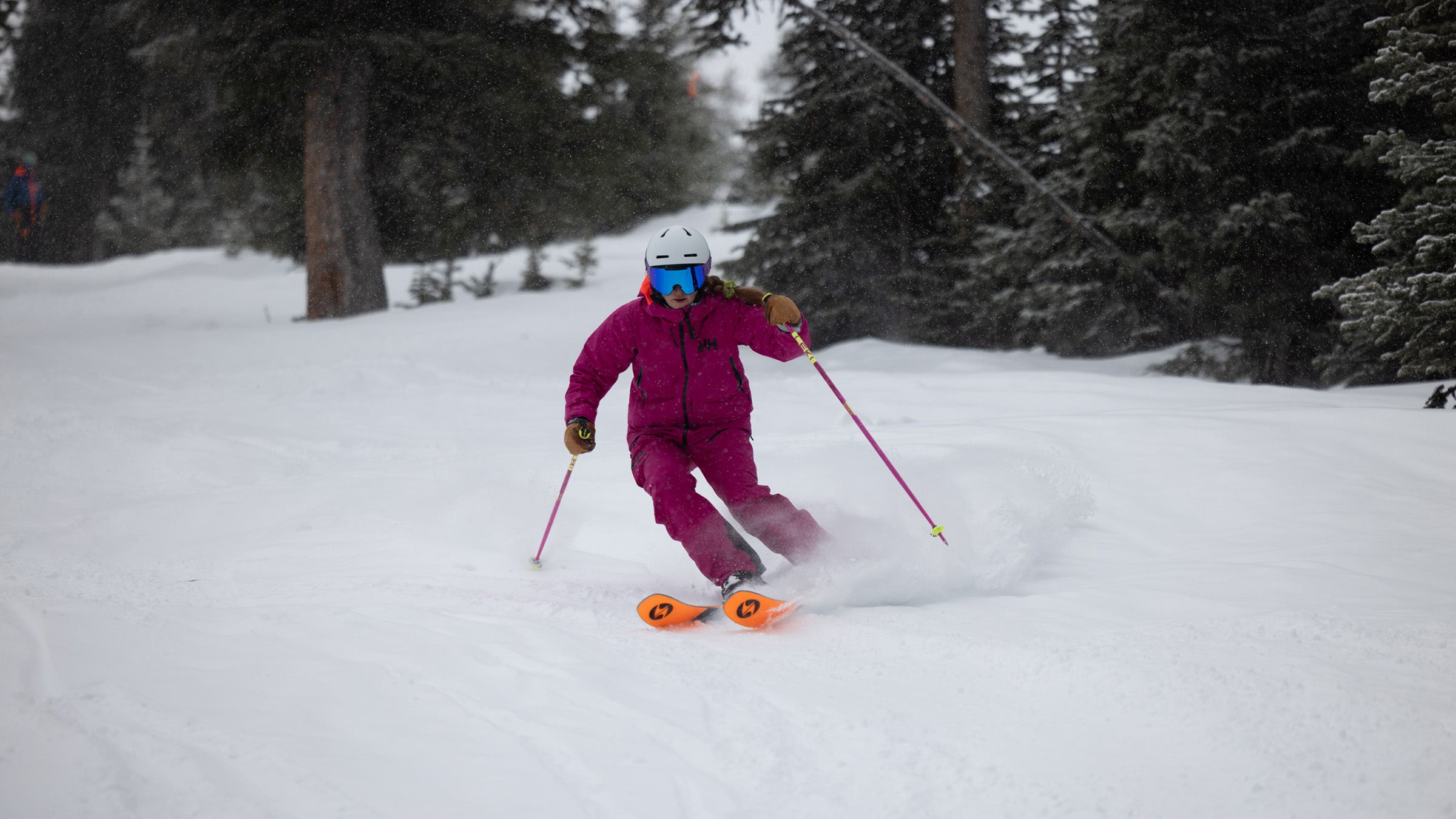 Woman in pink ski suit skiing on snow