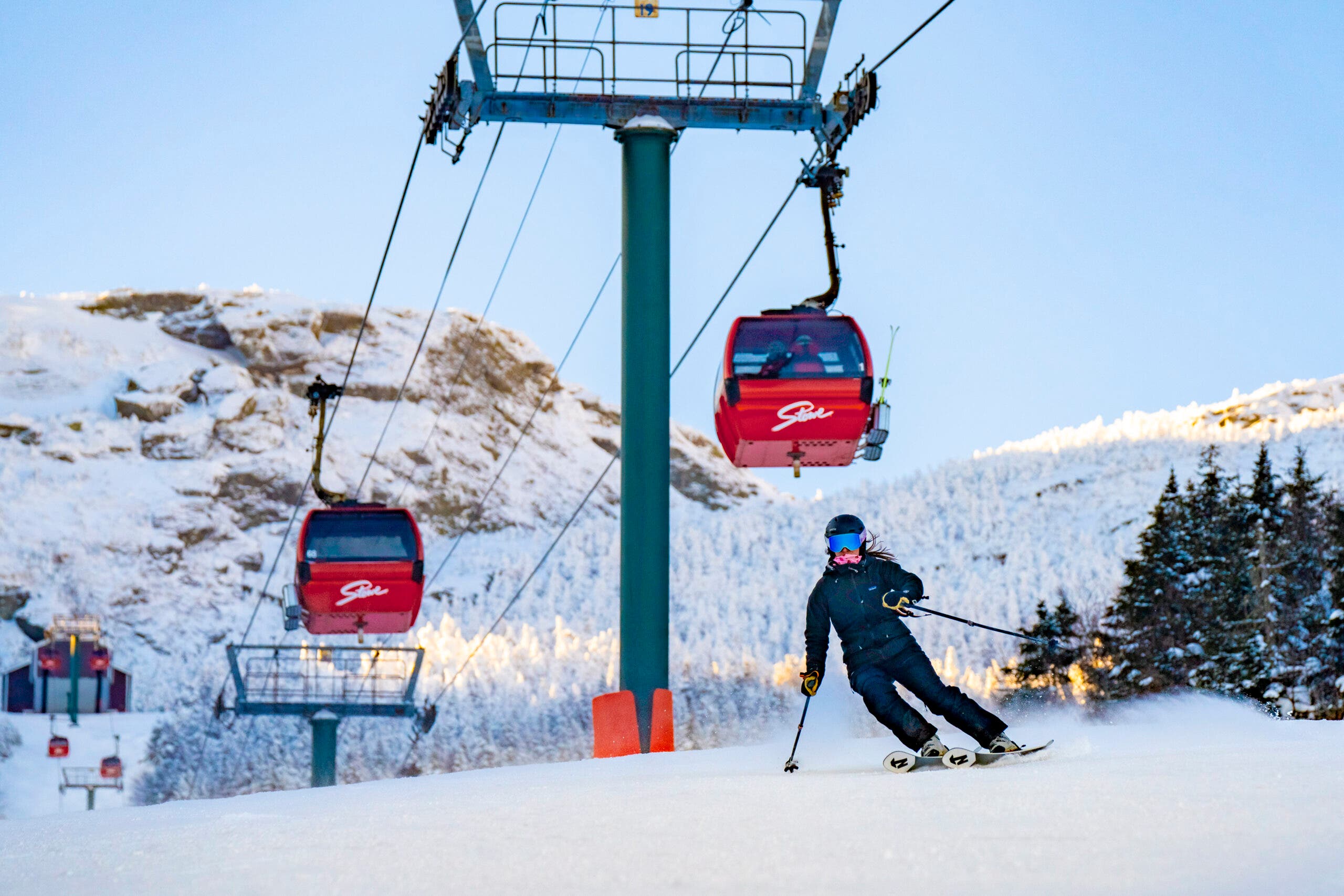 Orang bermain ski di bawah gondola