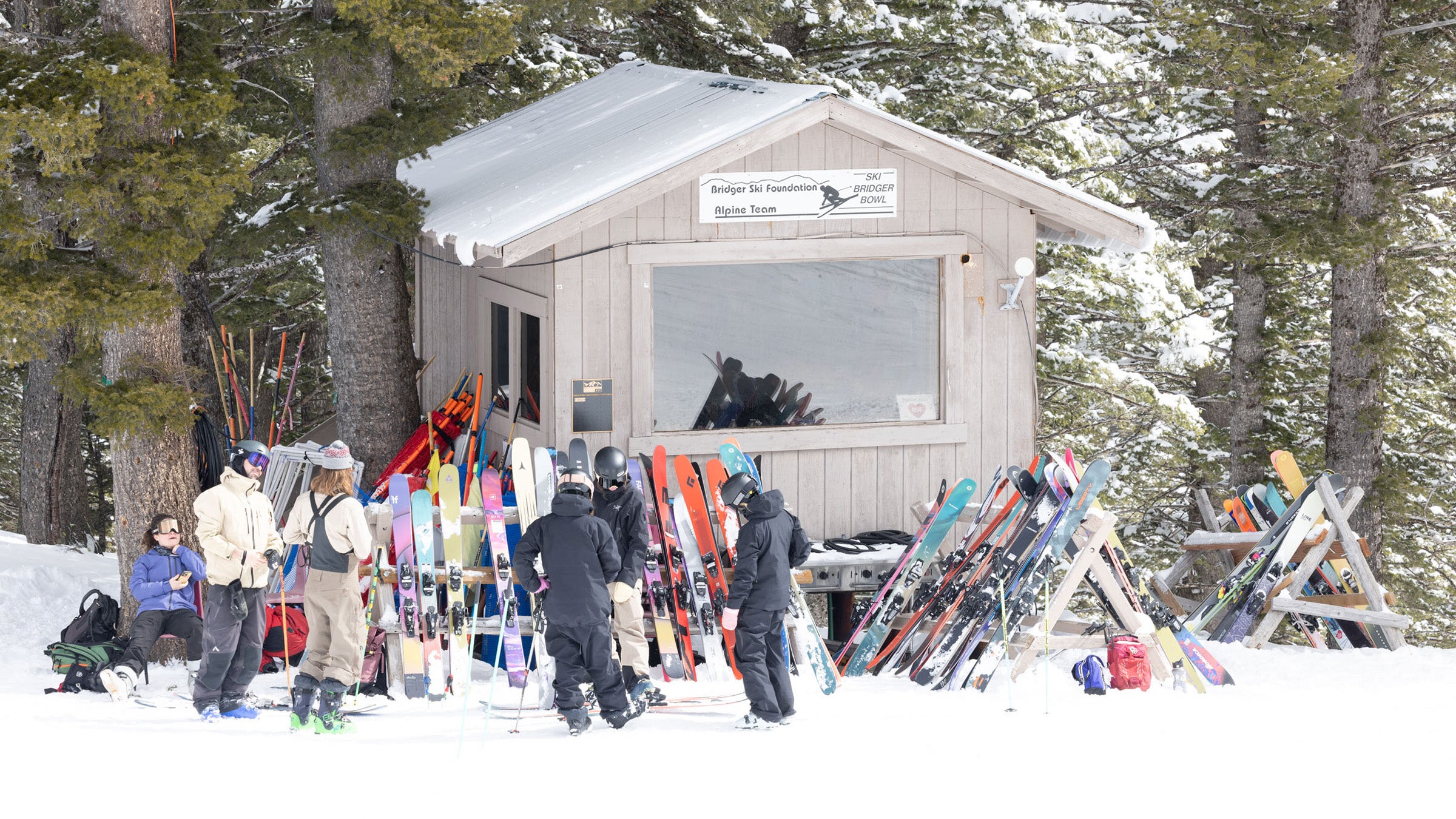 Shack on ski hill with powder skis on racks out front