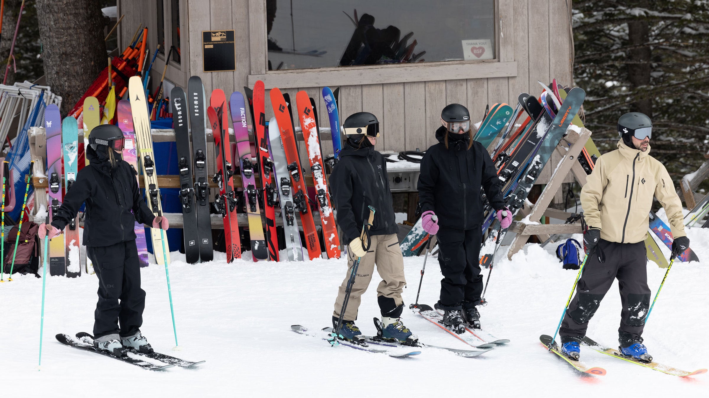 Skiers on powder skis skating away from cabin