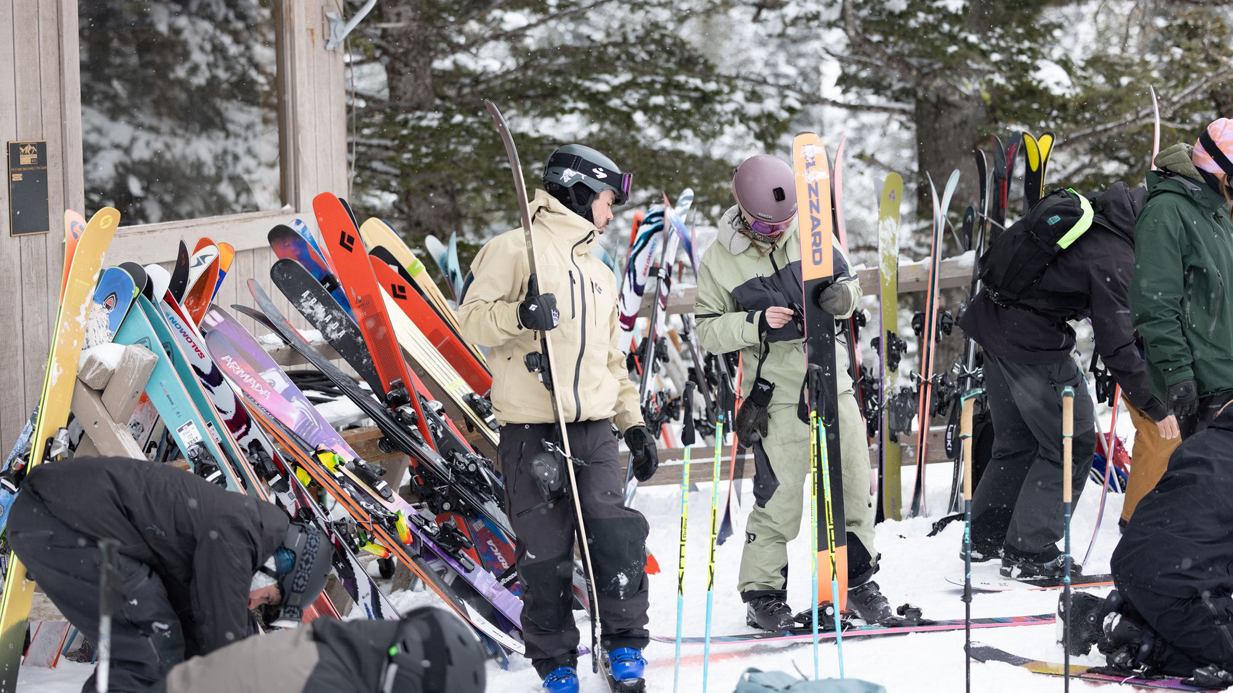 Skiers choosing powder skis from ski racks