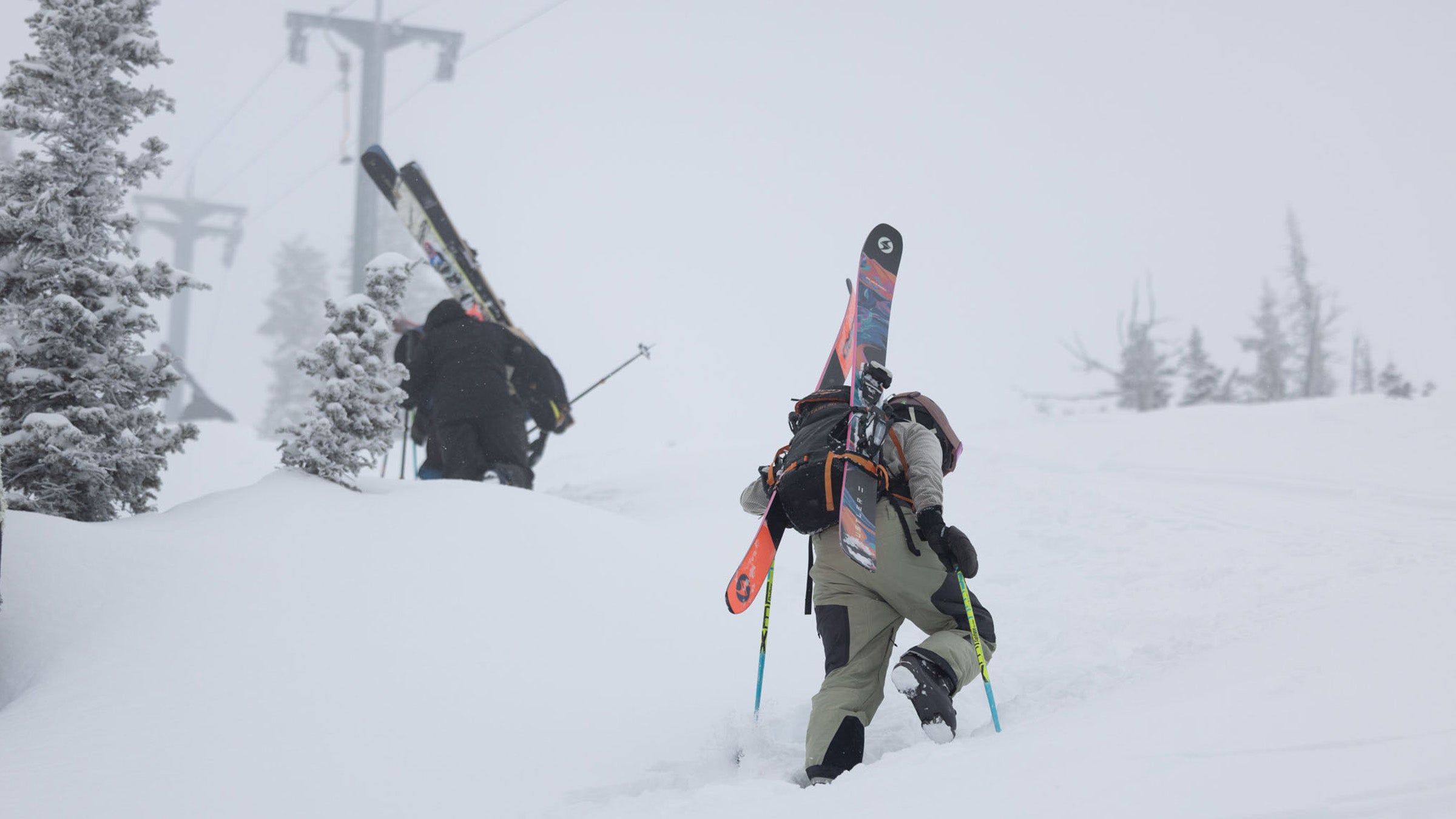 Skier boot packing through powder with skis strapped to backpack