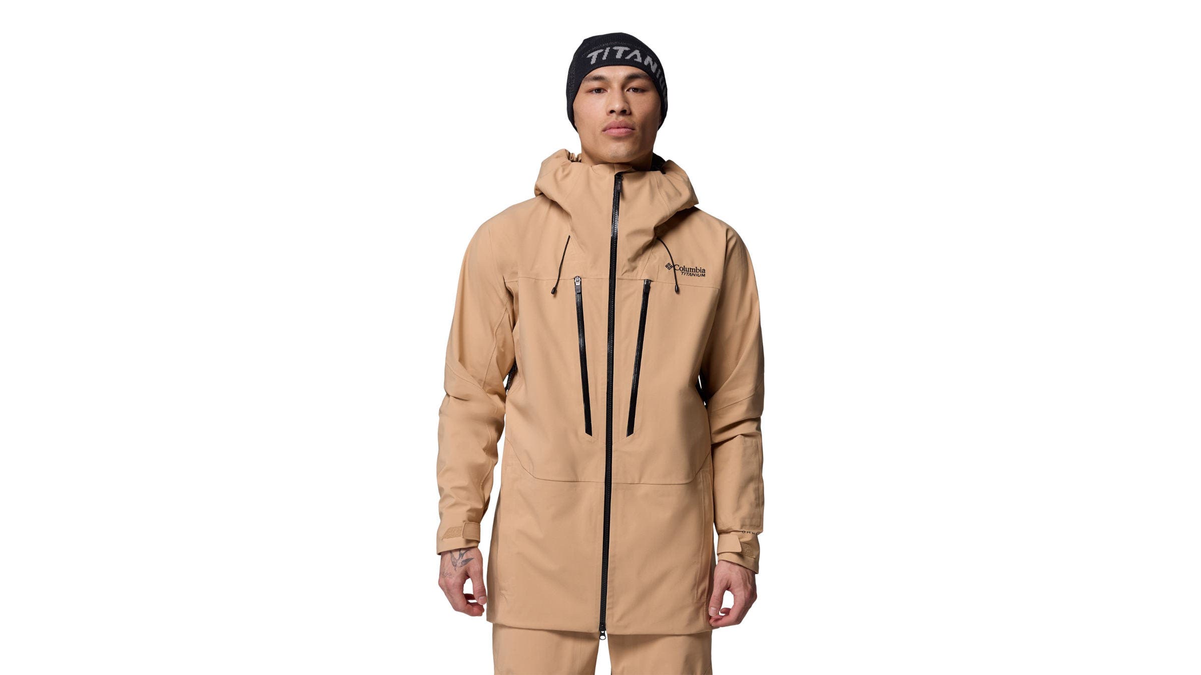 A man wearing a a beige Columbia Platinum Peak II 3L Shell in front of a white background. 