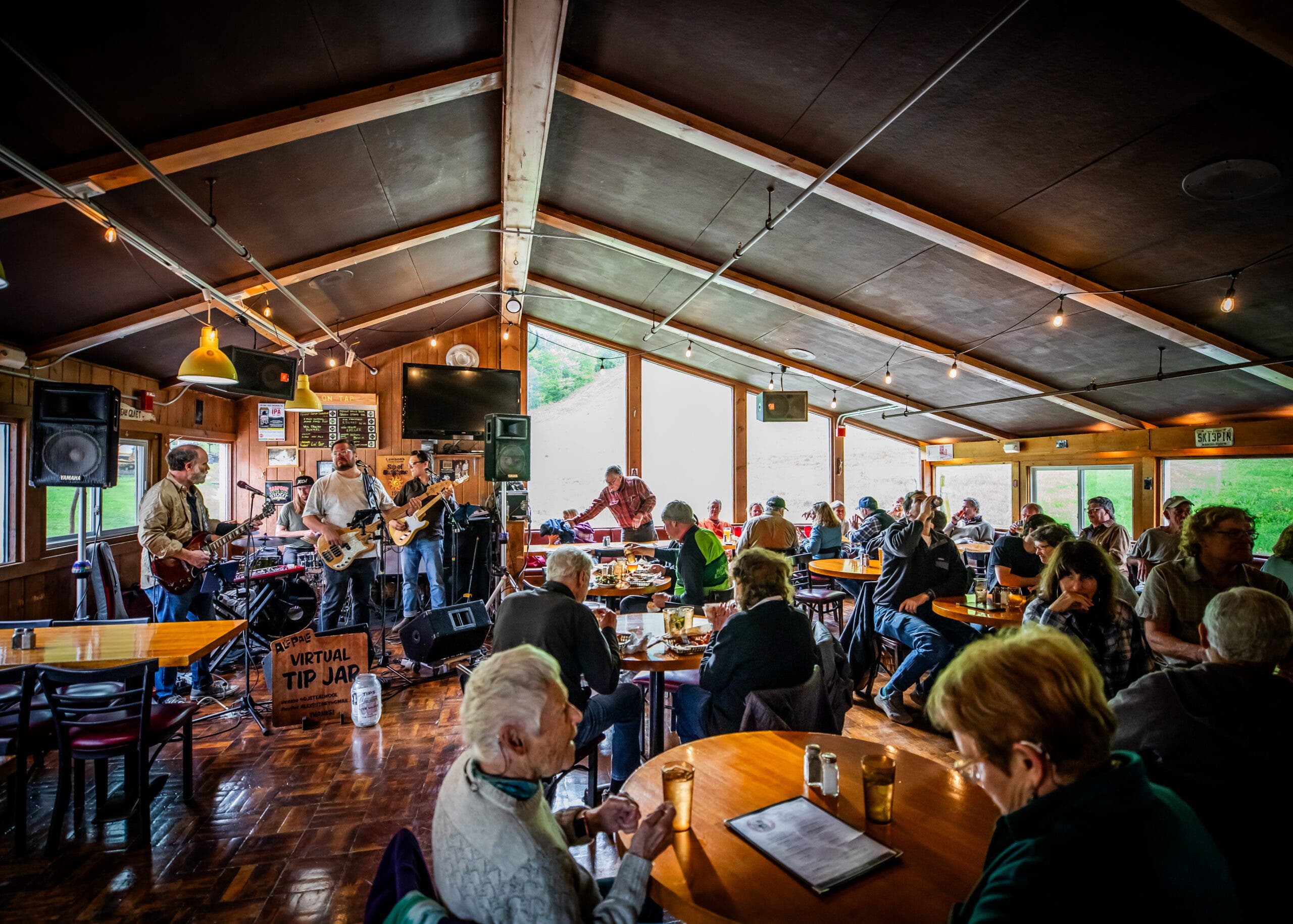 Orang-orang duduk di bar dengan musik di Mad River Glen