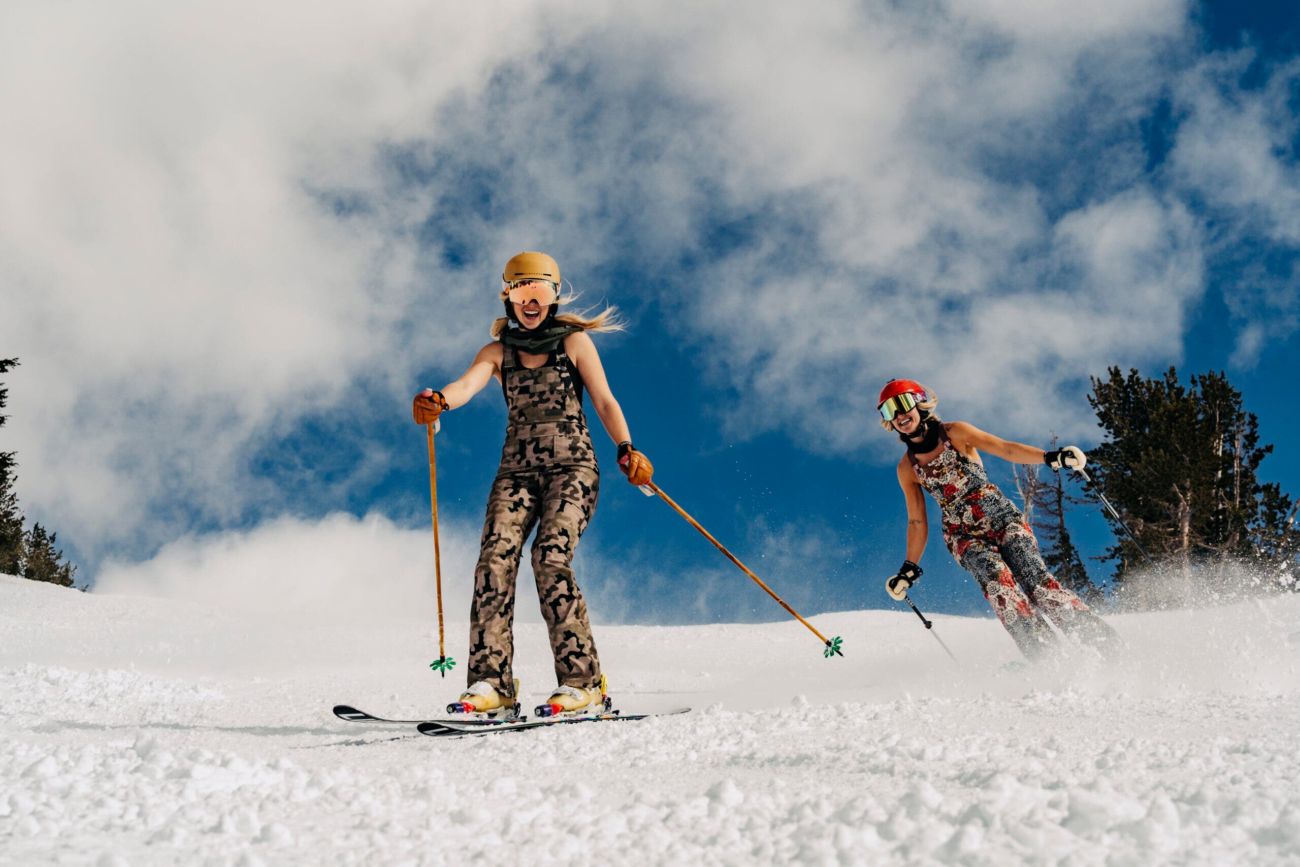 Two skiers in overalls spring skiing