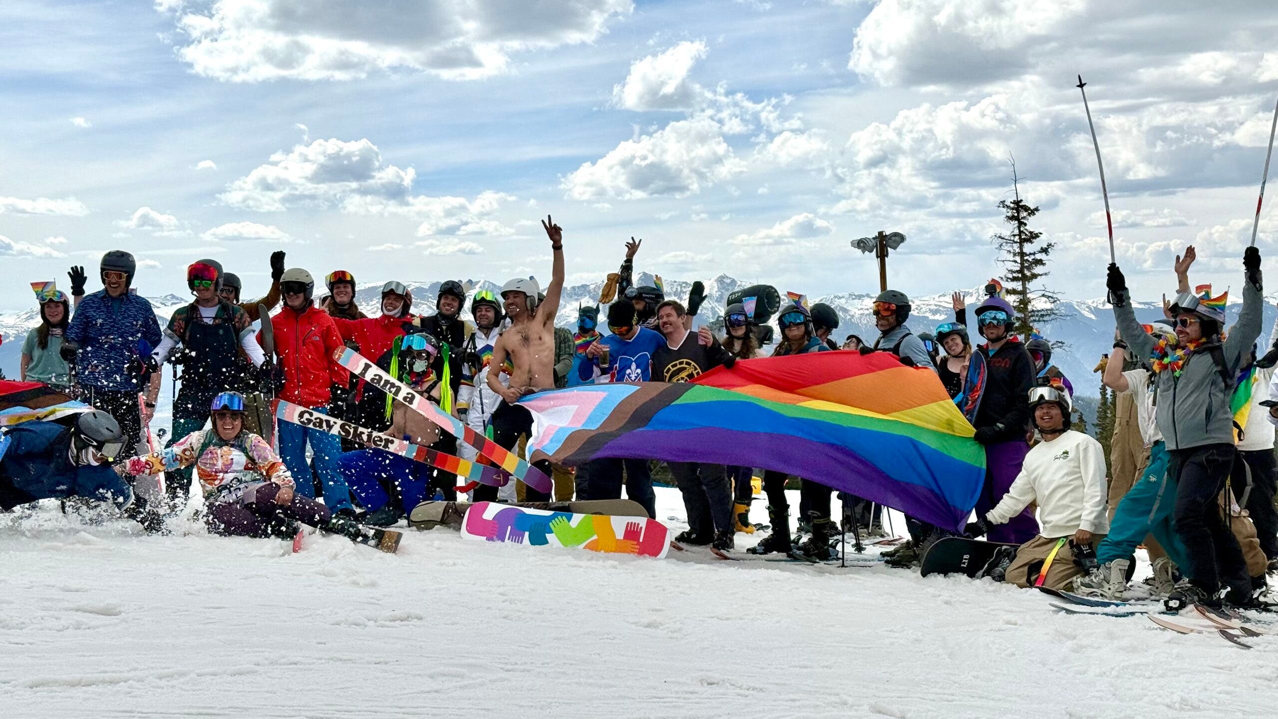 Skiers and snowboarders pose at the top of Schoolmarm before riding down for the Pride parade run.