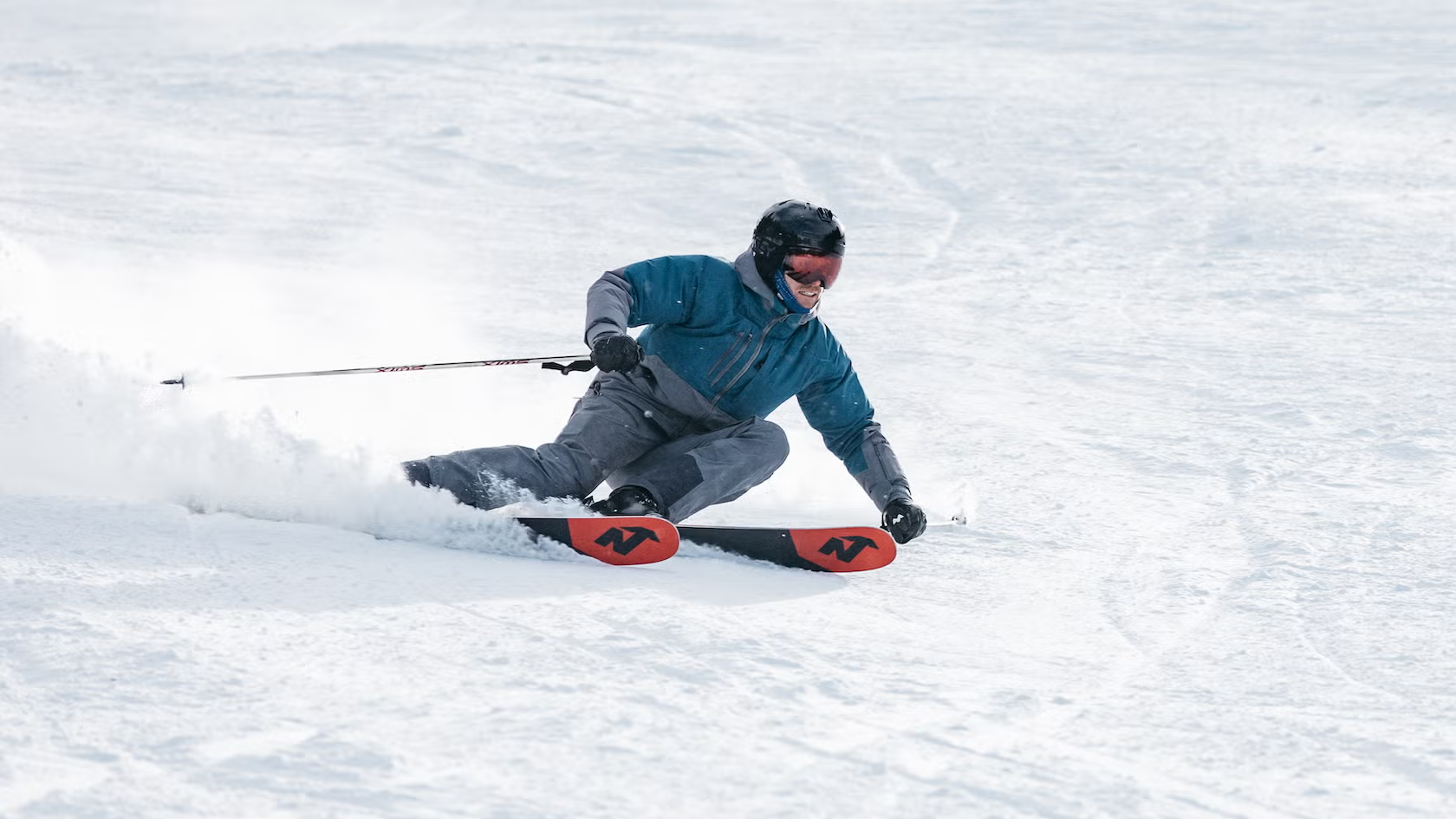 Skier carving on Nordica Enforcer all-mountain skis on groomed run during SKI Test