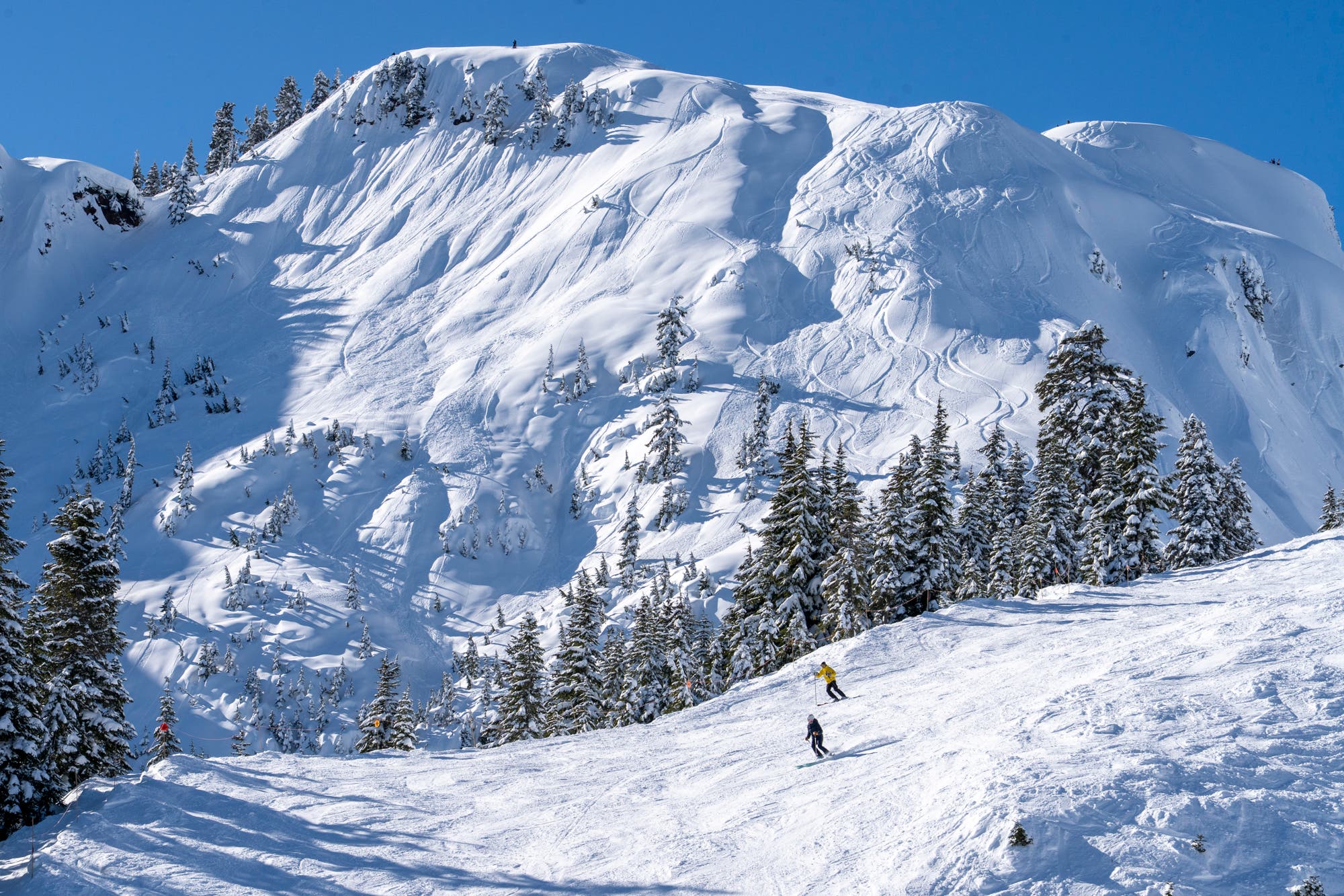 Covered rocks with skiers in the foreground